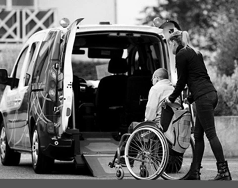 A woman assists a man in a wheelchair, showcasing compassion and support in a caring environment.